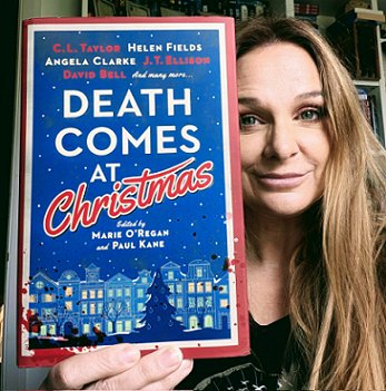 photograph of a smiling CL Taylor holding a copy of Death Comes at Christmas