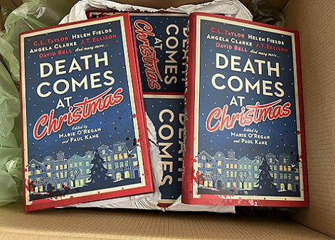 photograph showing multiple copies of Death Comes at Christmas, edited by Marie O'Regan and Paul Kane, in an open cardboard box