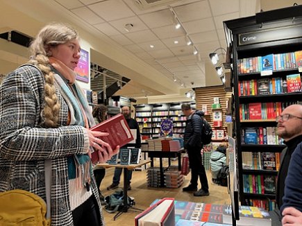 Tom Mead talking to a customer holding one of his books