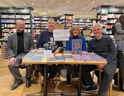 L to R: a smiling Tom Mead, Russ Thomas, Marie O'Regan and Paul Kane, sitting at a table featuring their books