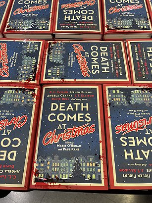 photograph of several copies of Death Comes at Christmas, edited by Marie O'Regan and Paul Kane