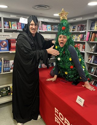 Russ Thomas (dressed as Death) pretending to strangle Tina Baker (dressed as a Christmas tree)