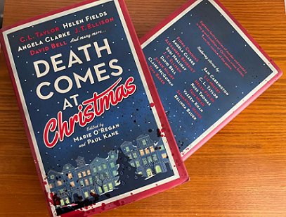 photograph of two copies of Death Comes at Christmas, edited by Marie O'Regan and Paul Kane, on a wooden surface