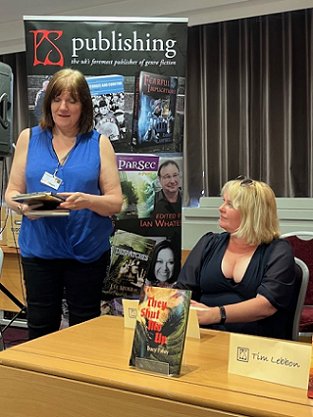 photograph of Absinthe Books editor Marie O'Regan standing, introducing the 2023 titles. Seated beside her is author Tracy Fahey