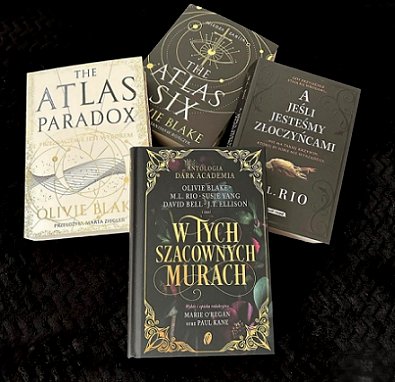 display featuring four books on a black background. The Atlas Paradox and The Atlas Six by Olivie Blake, and In These Hallowed Halls, edited by Marie O'Regan and Paul Kane