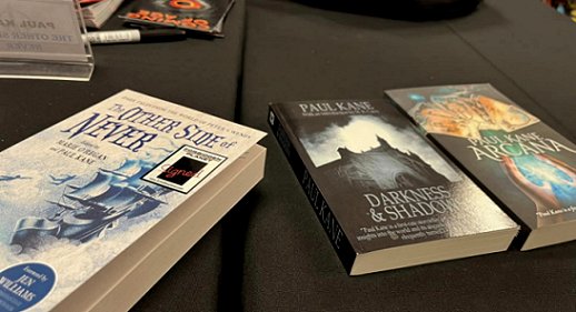 Three books on a table - The Other Side of Never, edited by Marie O'Regan and Paul Kane, Darkness and Shadows by Paul Kane and Arcana by Paul Kane