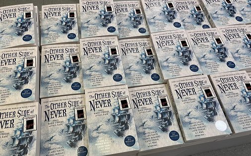 Display of multiple signed copies of The Other Side of Never, edited by Marie O'Regan and Paul Kane