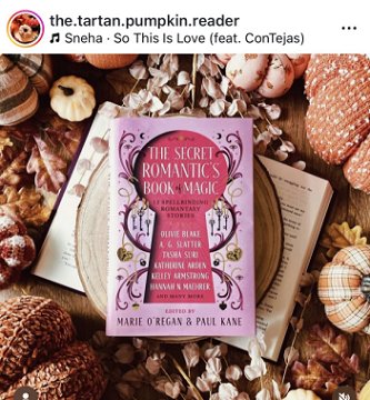 photograph of a copy of The Secret Romantic's Book of Magic, edited by Marie O'Regan and Paul Kane, on a beige platter on top of an open book. Surrounding this are dried white flowers, dry leaves, and a selection of knitted and cloth pumpkins in autumnal shades